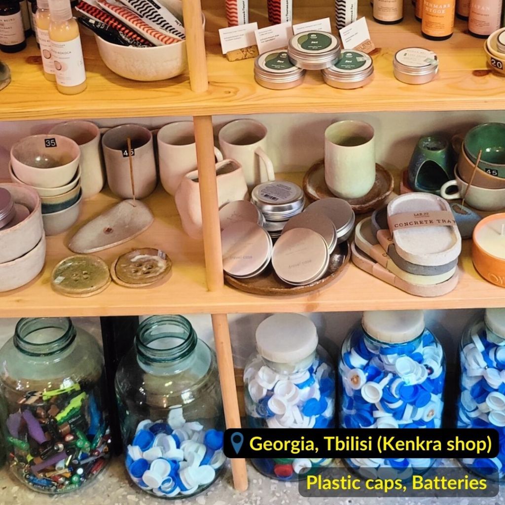 Plastic caps and batteries in big glass jars collected in recycling point in "Kenkra" shop in Tbilisi Georgia